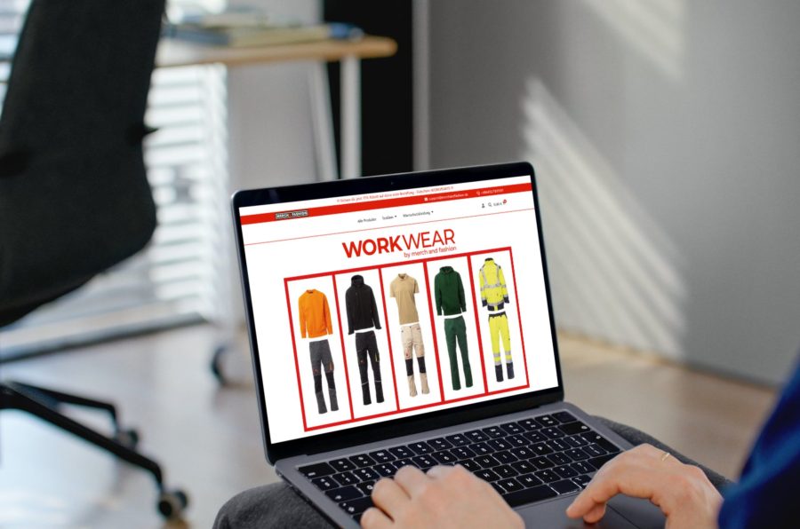 workwear-canva-033 Person surft im Online-Shop WorkWear by Merch and Fashion und betrachtet Arbeitskleidung auf einem Laptop